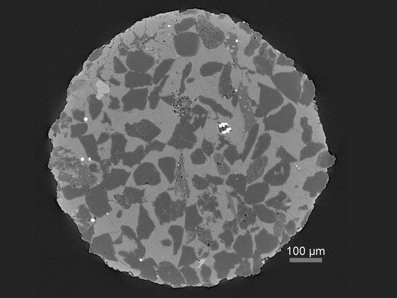 Virtual cross-section through a heterogeneous rock sample revealing multiple phases and porosity.