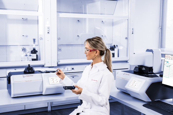 A woman wearing a lab coat prepares to use the DSC machine.