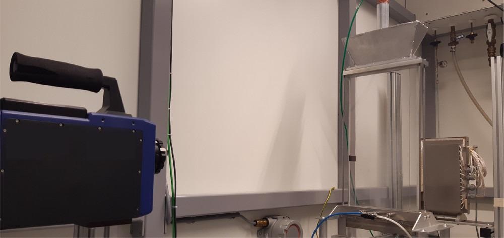 Experimental setup consisting of the IR source on the right, quartz glass column in the middle, and IR camera on the left.