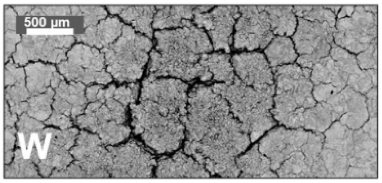 Surface damage with cracks induced by electron beam pulses.