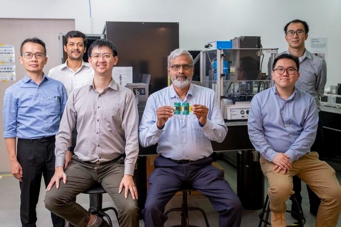 (L-R) Members of the multi-material 3D printer team include Co-leader, Dr Low Mun Ji, General Manager, Panasonic; Dr Suchand Sandeep, Research Fellow, NTU School of Mechanical and Aerospace Engineering (MAE); Dr Nicholas Tham, Senior Research Engineer, Panasonic; Co-leader, Associate Professor Murukeshan Vadakke Matham, NTU School of MAE, Singapore Centre for 3D Printing; Dr Joel Lim, Research Engineer, Panasonic, and Mr Daryl Lim, Research Associate, NTU School of MAE, with the newly developed printer in the background. Assoc Prof Murukeshan is holding onto a sample of a 3D printed stretchable pressure sensor.