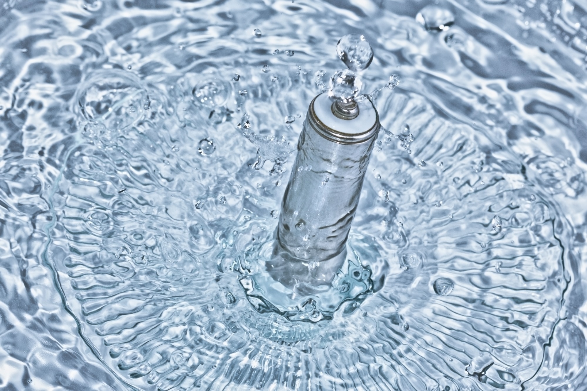 A rechargeable battery emerging out of crystal clear blue water