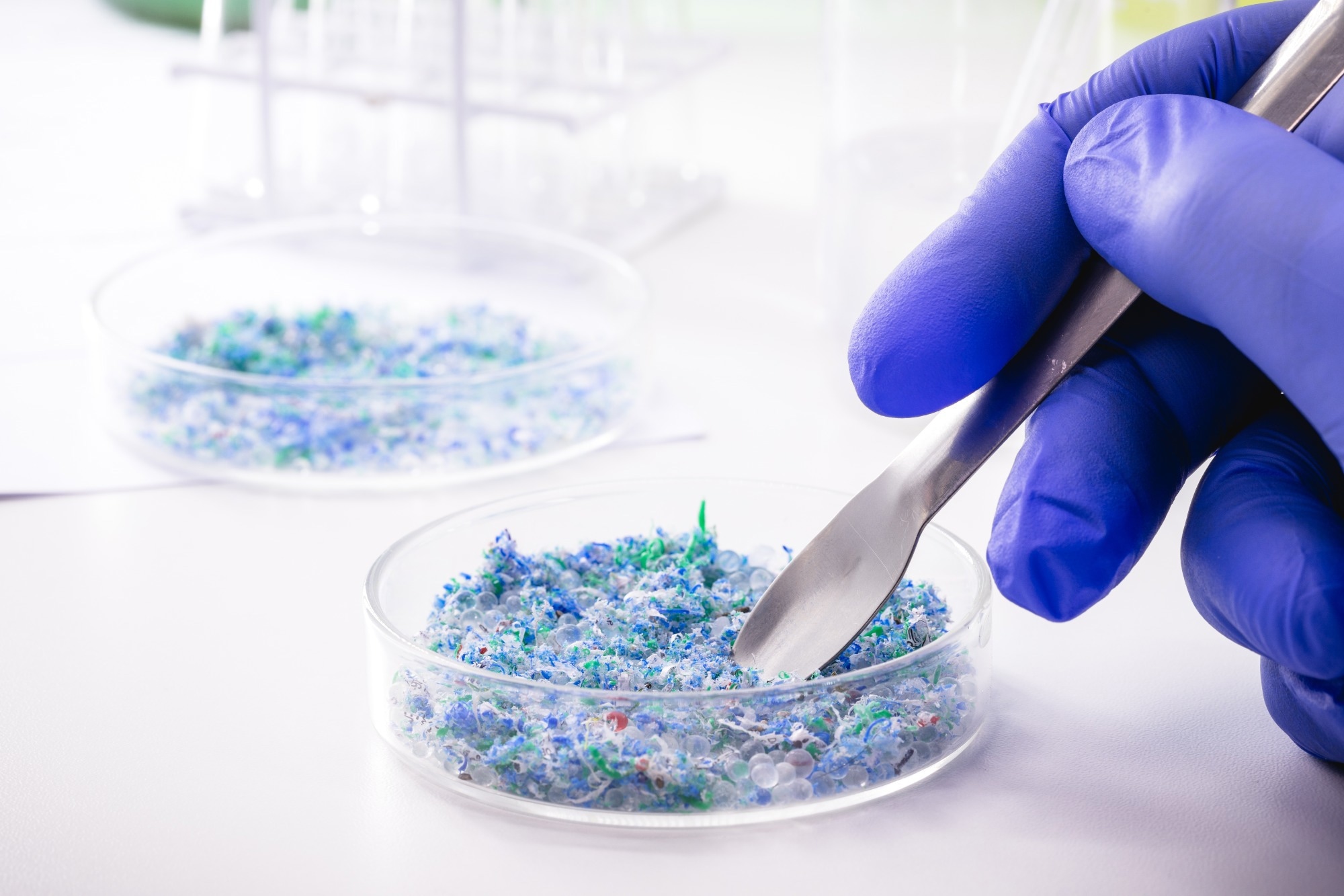 hand of traces of plastic and microplastic in petri dish, analyzed in laboratory,
