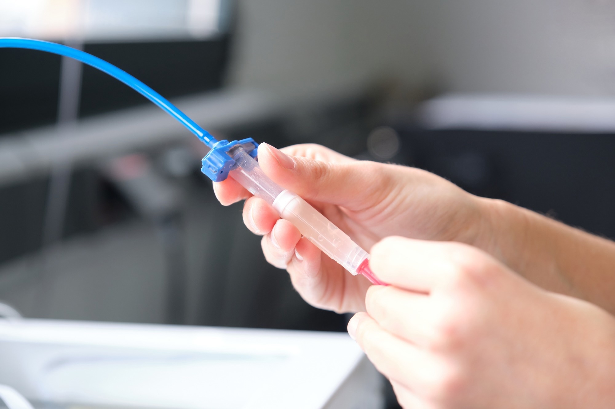 Researcher loading the ink cartridge of a 3D bioprinter to 3D print cells onto an electrode.