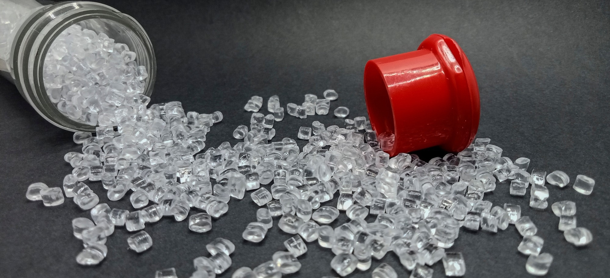 Polypropylene beads falling out of a jar.