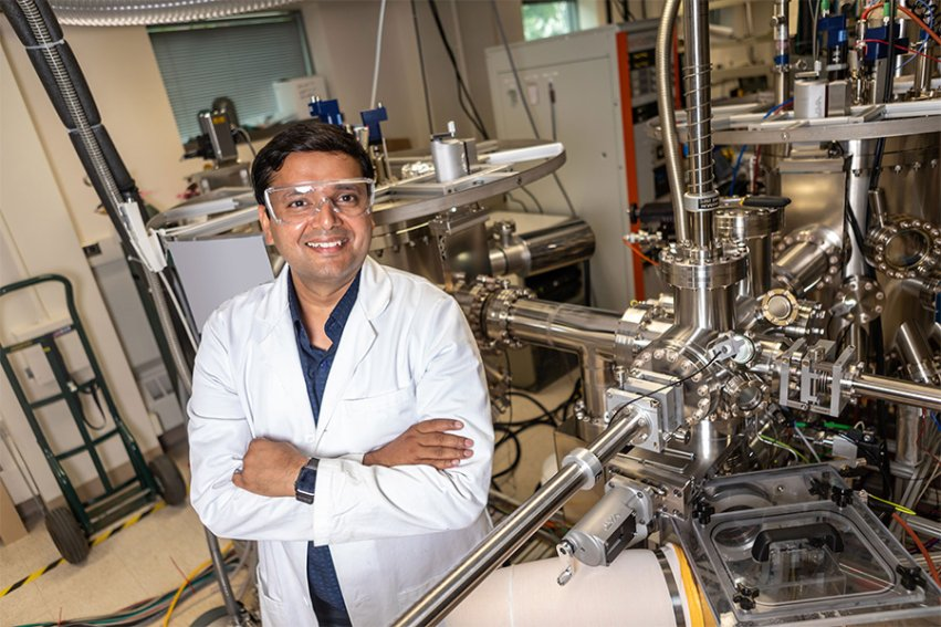 Bharat Jalan in his research lab standing next to equipment.