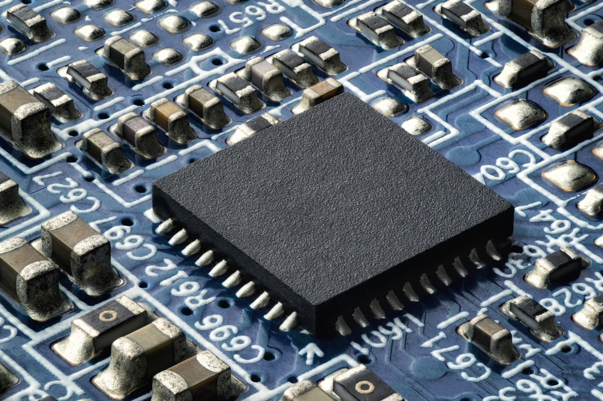 Small semiconductor on a circuit board. Extreme closeup of a chip integrated in a modern electronic device.