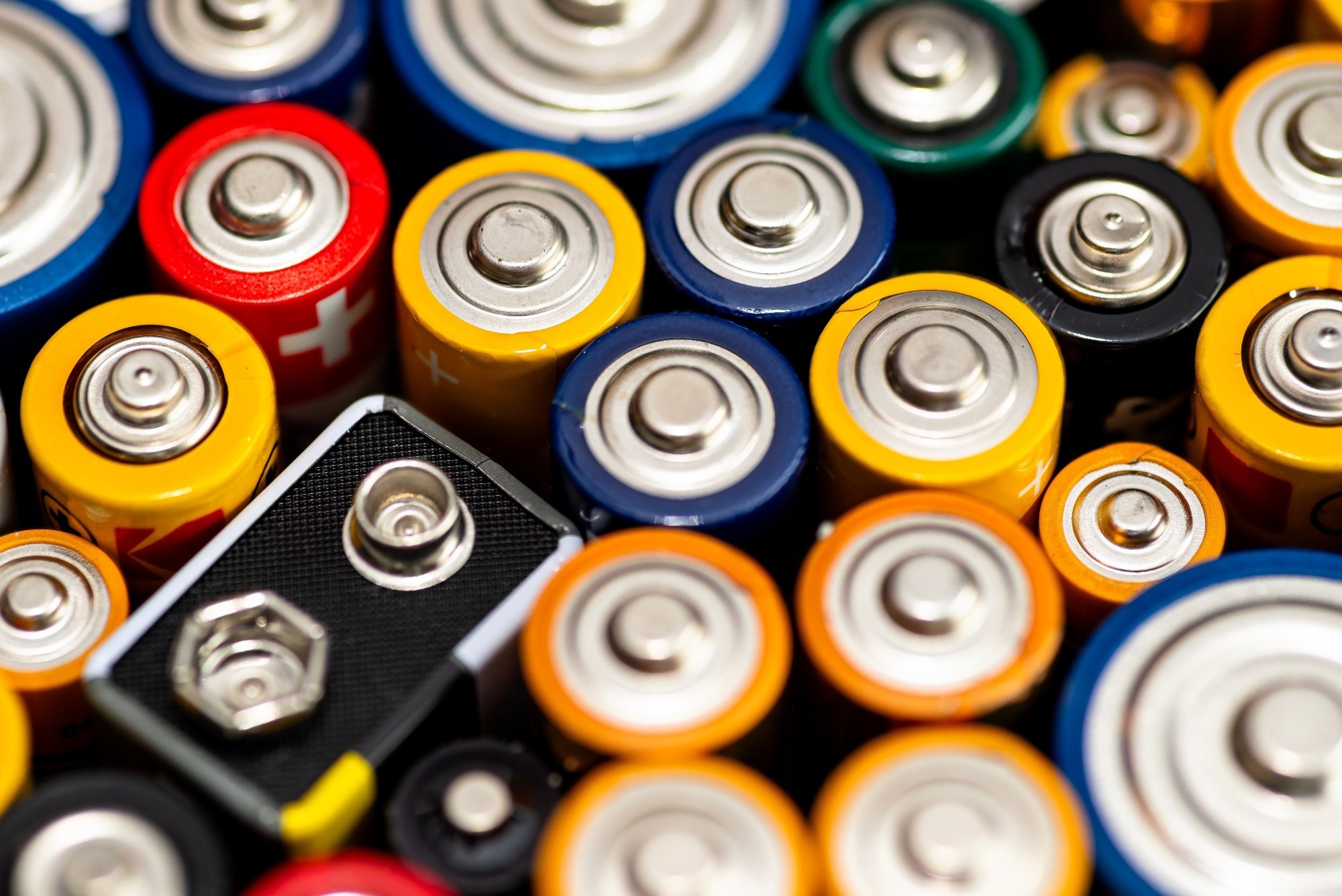 Various alkaline and lithium-ion batteries, positive pole visible.