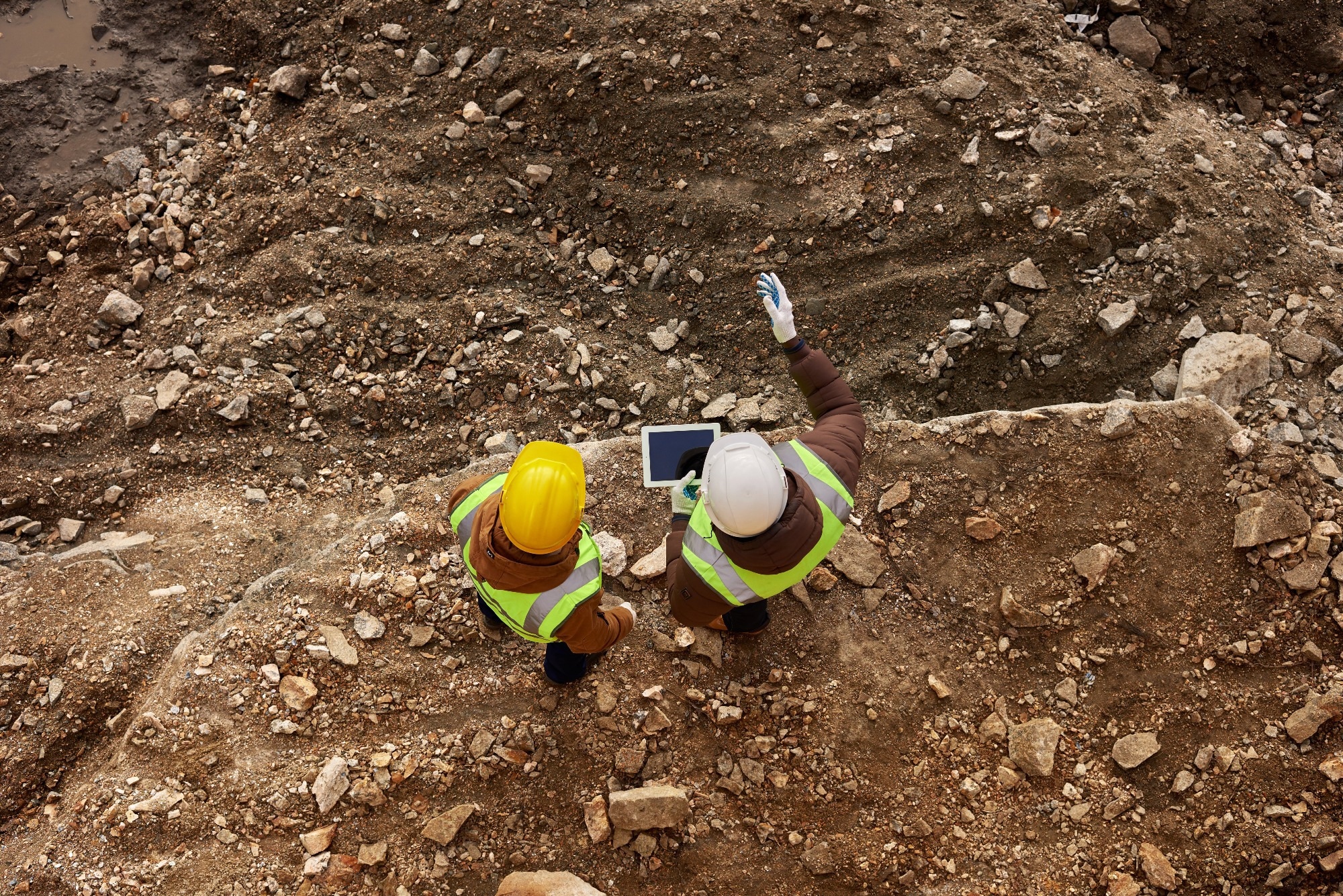 Two engineers assess the ground, surveying a site for the best drilling start point.
