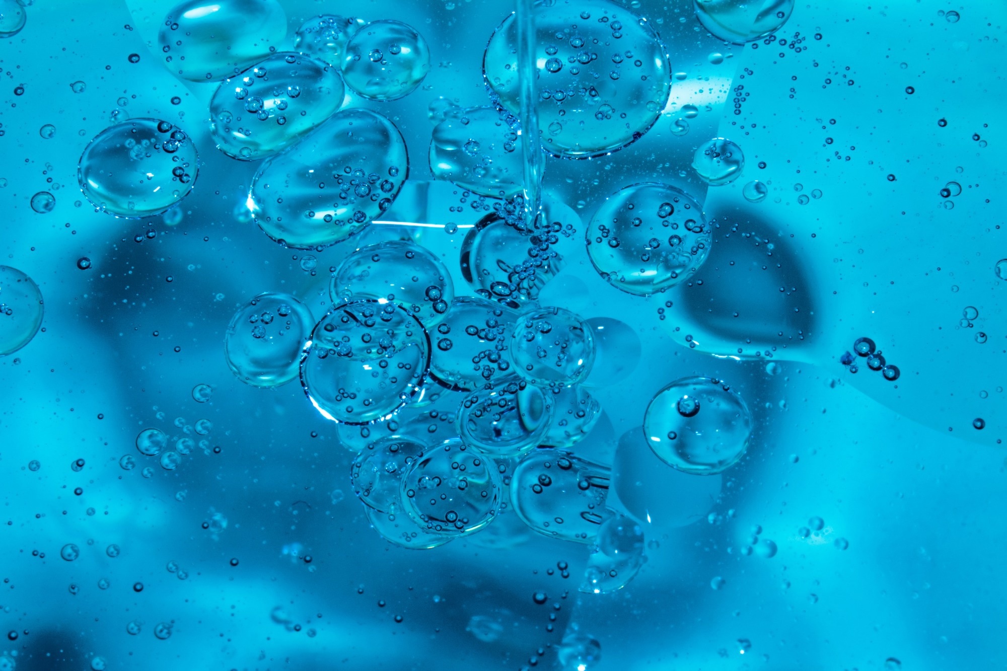 Bright blue hydrogel close up picture with bubbles in the centre of the image.