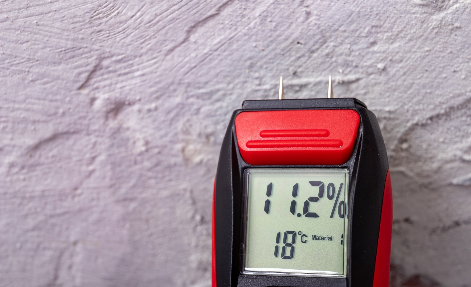 A red sensor monitors moisture content in a wall.