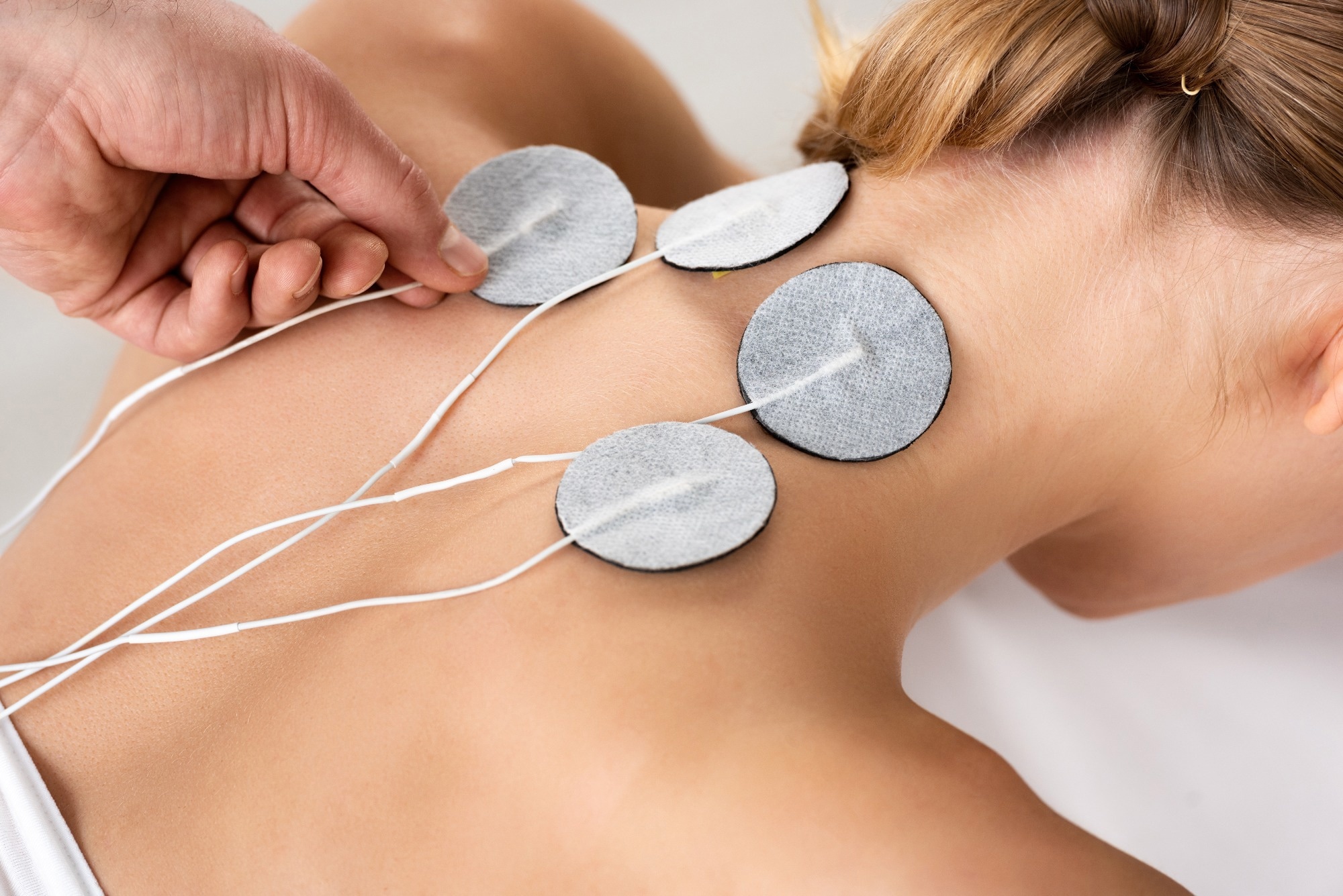 woman receiving flexible electrodes on neck
