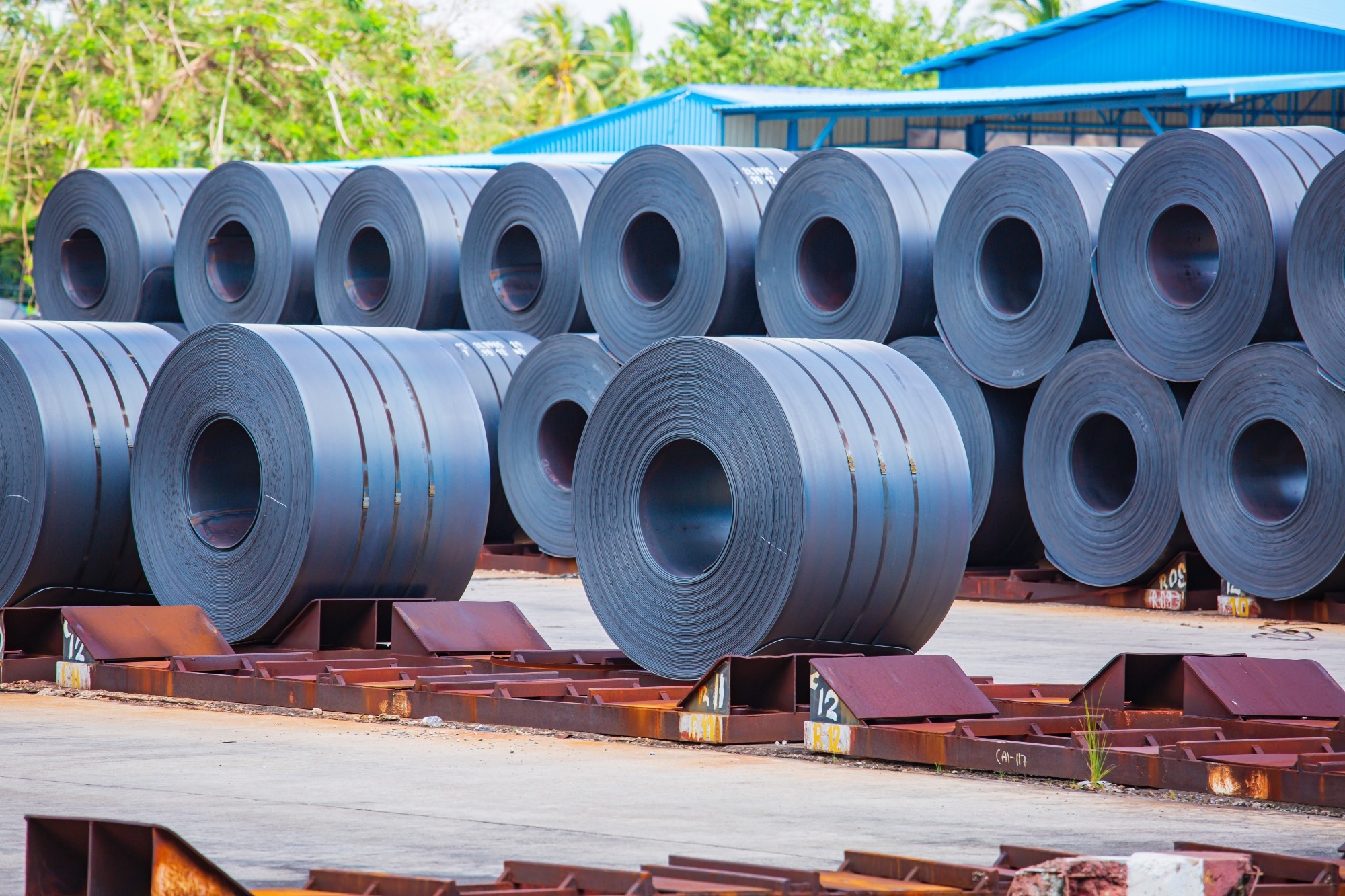 Rolls of carbon steel sheets outside the factory or warehouse.