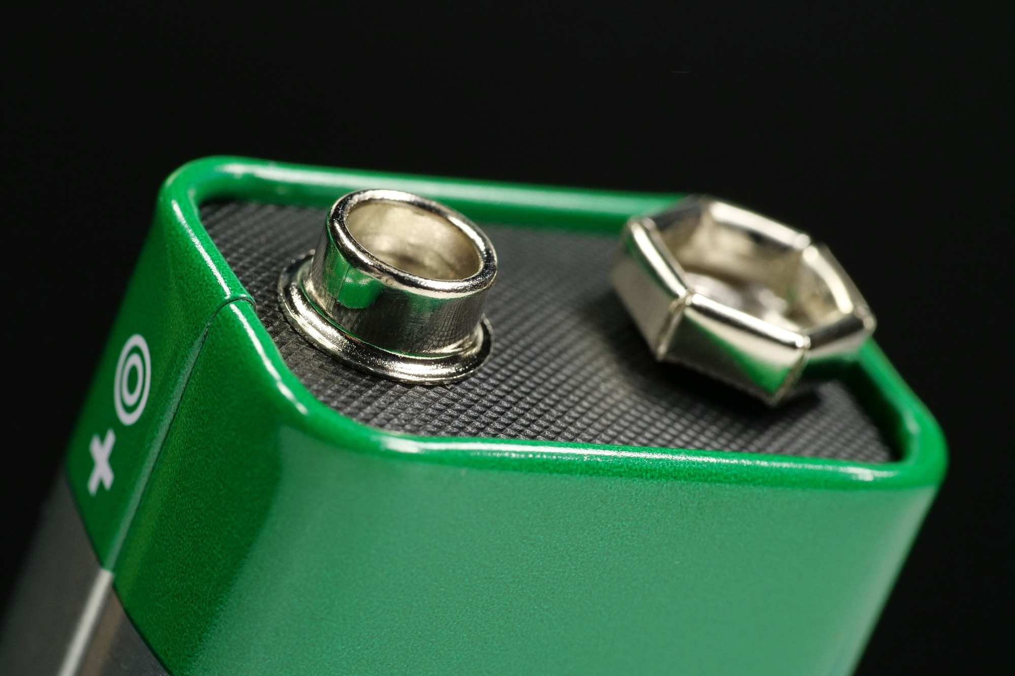 Green nine-volt battery with terminals ready to power devices